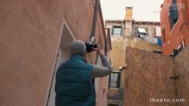 斯坦尼康拍摄的一个女人使用专业的摄影相机拍摄的老房子的<strong>外观</strong>在意大利威尼斯